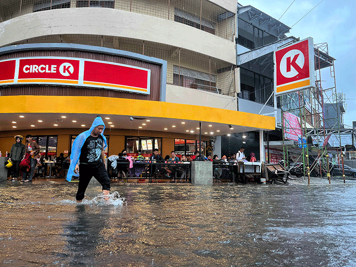 Sejumlah pengendara menerobos banjir yang menutupi jalan protokol pusat Kota Makassar, Senin (13/2/2023).