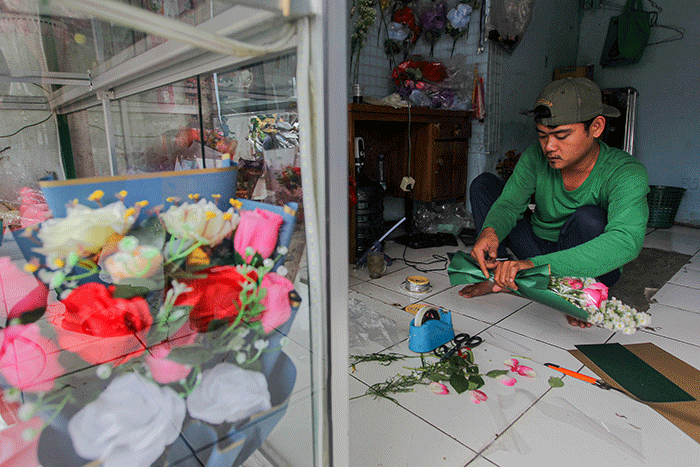 Penjual bunga saat membuat pesanan bucket mawar di Jalan Raya Pondok Gede, Jakarta Timur, Selasa (14/2/2023).
