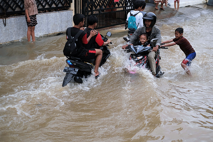 Sejumlah anak-anak bermain di tengah banjir di kawasan Jalan Nipa-nipa, Makassar, Kamis (15/2/2023).