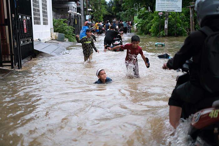 Sejumlah anak-anak bermain di tengah banjir di kawasan Jalan Nipa-nipa, Makassar, Kamis (15/2/2023).
