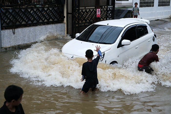 Sejumlah anak-anak bermain di tengah banjir di kawasan Jalan Nipa-nipa, Makassar, Kamis (15/2/2023).