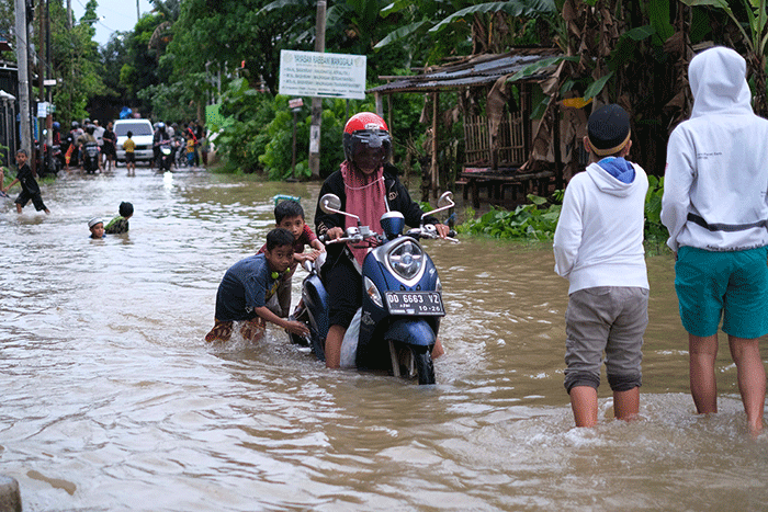 Sejumlah anak-anak bermain di tengah banjir di kawasan Jalan Nipa-nipa, Makassar, Kamis (15/2/2023).