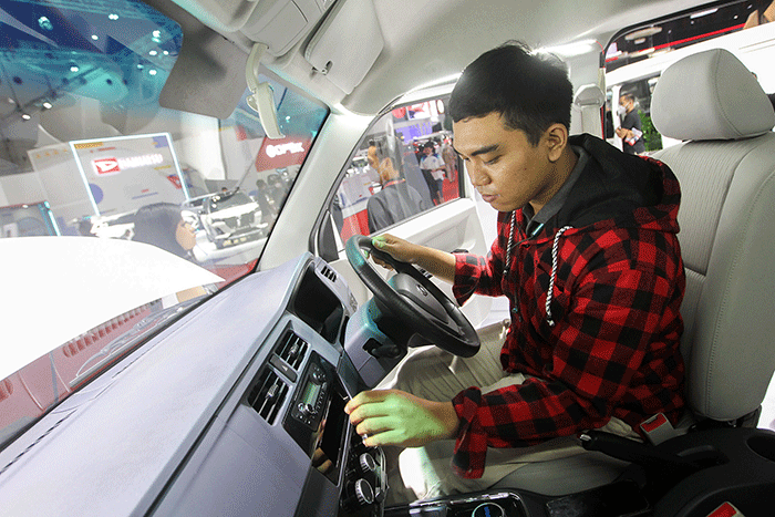 Pengunjung saat melihat mobil yang dipamerkan dalam pameran Indonesia International Motor Show (IIMS) 2023 di JIExpo Kemayoran, Jakarta, Jumat (17/2/2023).