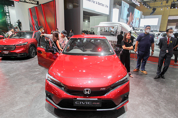 Pengunjung saat melihat mobil yang dipamerkan dalam pameran Indonesia International Motor Show (IIMS) 2023 di JIExpo Kemayoran, Jakarta, Jumat (17/2/2023).