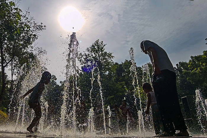 Anak-anak asik bermain air mancur di Taman Puring, Jakarta, Minggu (19/2/2023).