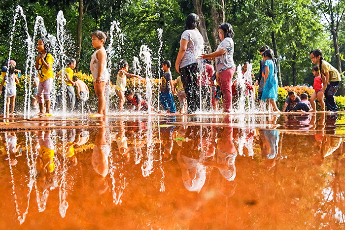Anak-anak asik bermain air mancur di Taman Puring, Jakarta, Minggu (19/2/2023).