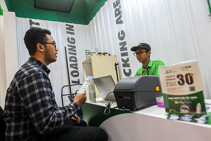Petugas saat merapikan paket yang akan dikirim di Booth J&T Cargo dalam pameran otomotif Indonesia International Motor Show (IIMS) 2023.
