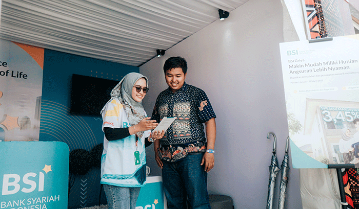 Pengunjung arena F1 PowerBoat melakukan transaksi perbankan di mobil kas keliling PT Bank Syariah Indonesia Tbk (BSI) di kawasan Danau Toba, Balige.