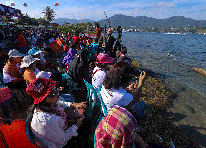Warga menyaksikan Kejuaraan Dunia Perahu Motor F1 PowerBoat (F1H2O) di pinggir Danau Toba, Balige, Sumatera Utara, Minggu (26/2/2023).