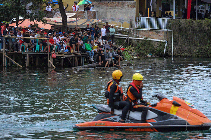 Warga menyaksikan Kejuaraan Dunia Perahu Motor F1 PowerBoat (F1H2O) di pinggir Danau Toba, Balige, Sumatera Utara, Minggu (26/2/2023).