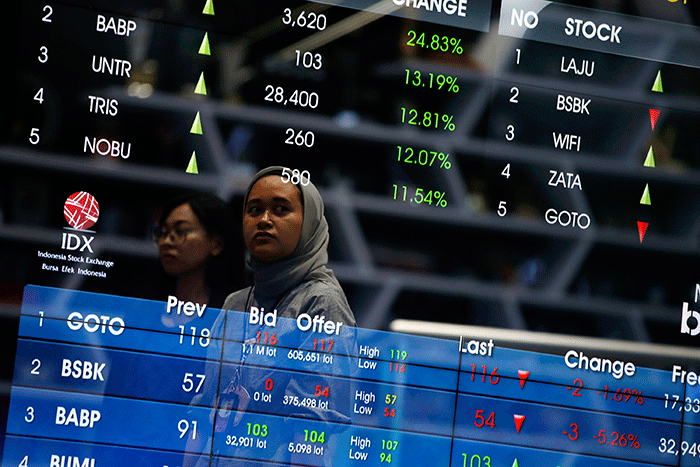 Karyawan berdiri di dekat layar pergerakan Indeks Harga Saham Gabungan (IHSG) di Bursa Efek Indonesia, Jakarta, Selasa (28/2/2022).