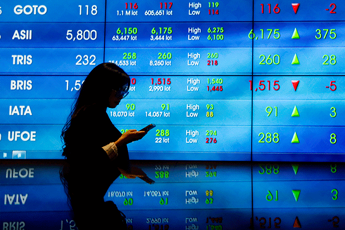 Karyawan berdiri di dekat layar pergerakan Indeks Harga Saham Gabungan (IHSG) di Bursa Efek Indonesia, Jakarta, Selasa (28/2/2022).