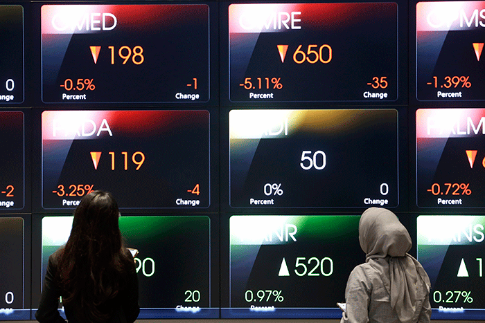 Karyawan berdiri di dekat layar pergerakan Indeks Harga Saham Gabungan (IHSG) di Bursa Efek Indonesia, Jakarta, Selasa (28/2/2022).