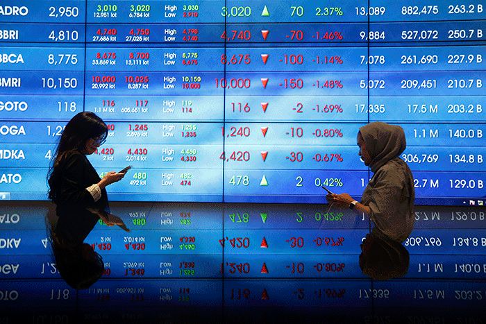 Karyawan berdiri di dekat layar pergerakan Indeks Harga Saham Gabungan (IHSG) di Bursa Efek Indonesia, Jakarta, Selasa (28/2/2022).