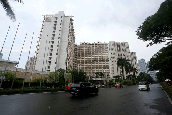 Warga melintas di depan Hotel Sultan, kawasan Gelora Bung Karno, Senayan, Jakarta, Jumat (3/3/2023).