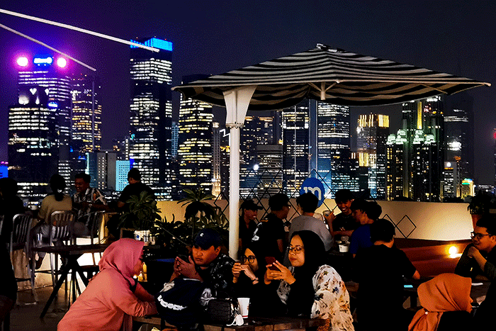 Pengunjung saat mengabadikan foto dengan suasana berlatar belakang pemandangan Gedung-gedung bertingkat dari tanjakan 13 di sebuah mall di Jakarta.