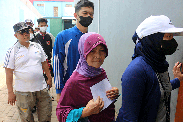 Warga menerima bantuan beras seberat 10 kg di kawasan Serdang Kemayoran, Jakarta, Sabtu (18/3/2023).