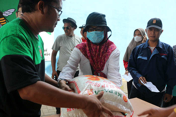 Warga menerima bantuan beras seberat 10 kg di kawasan Serdang Kemayoran, Jakarta, Sabtu (18/3/2023).