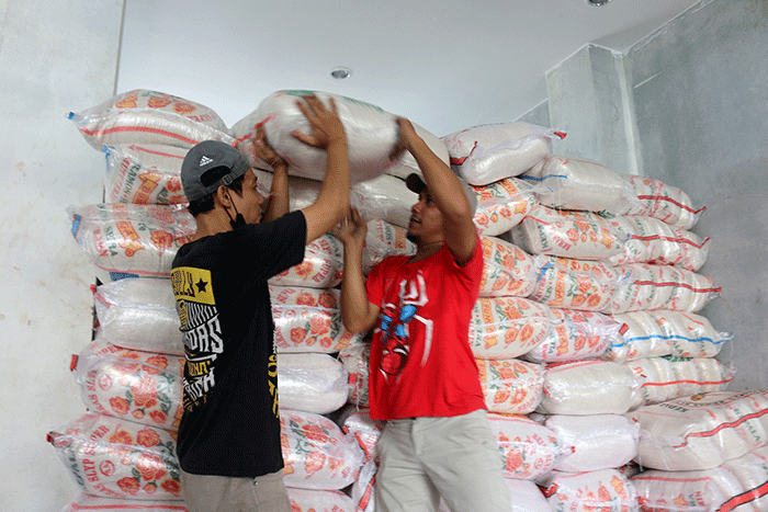Warga menerima bantuan beras seberat 10 kg di kawasan Serdang Kemayoran, Jakarta, Sabtu (18/3/2023).