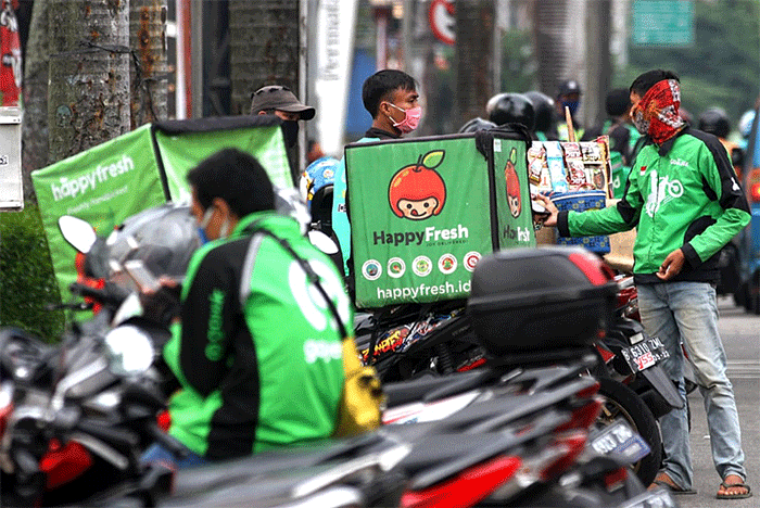 Mitra pengemudi Gojek sedang menunggu penumpang di Jakarta, Senin (20/3/2023).