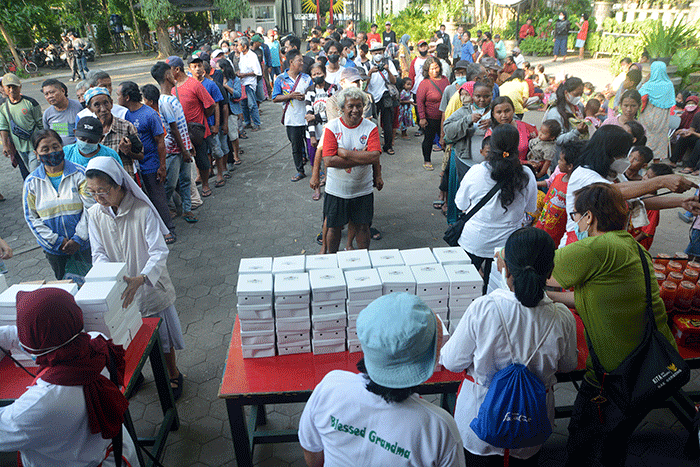 Ratusan warga mengantre untuk mendapatkan paket makanan untuk berbuka puasa yang dibagikan Tim Pelayanan Aksi Piring Kasih di Gereja Santa Theresia.