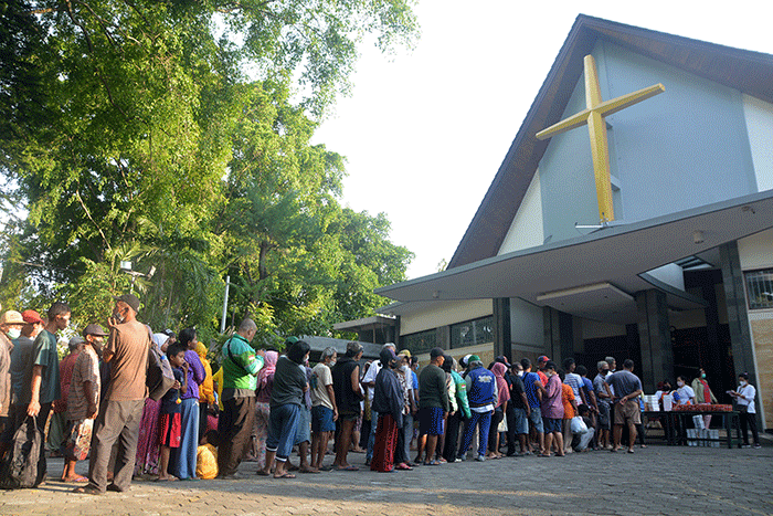Ratusan warga mengantre untuk mendapatkan paket makanan untuk berbuka puasa yang dibagikan Tim Pelayanan Aksi Piring Kasih di Gereja Santa Theresia.