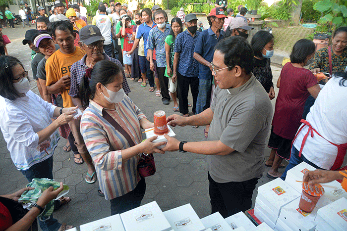 Ratusan warga mengantre untuk mendapatkan paket makanan untuk berbuka puasa yang dibagikan Tim Pelayanan Aksi Piring Kasih di Gereja Santa Theresia.