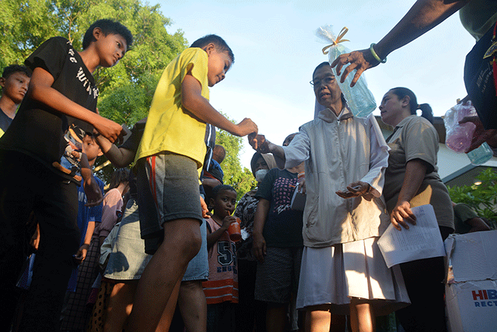 Ratusan warga mengantre untuk mendapatkan paket makanan untuk berbuka puasa yang dibagikan Tim Pelayanan Aksi Piring Kasih di Gereja Santa Theresia.