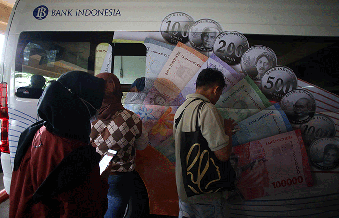 Warga menukarkan uang tunai baru di layanan kas keliling Bank Indonesia di Pasar Pramuka, Jakarta, Senin (27/3/2023).