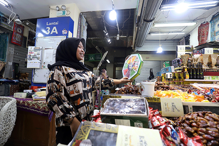 Pedagang menawarkan kurma yang dijual secara siaran langsung melalui medsos di Kawasan Thamrin City, Jakarta Pusat, Jumat (31/3/2023).