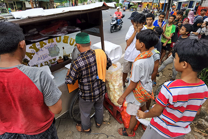 Warga saat mengantre bubur ayam gratis untuk berbuka puasa di kawasan Jakarta Barat, Minggu (2/4/2023).