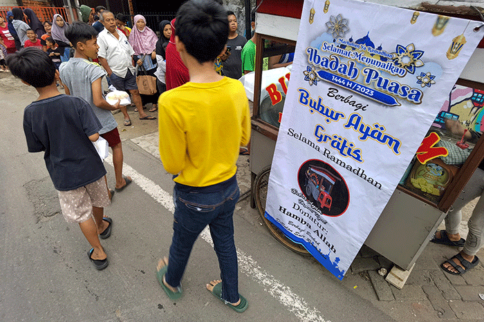 Warga saat mengantre bubur ayam gratis untuk berbuka puasa di kawasan Jakarta Barat, Minggu (2/4/2023).