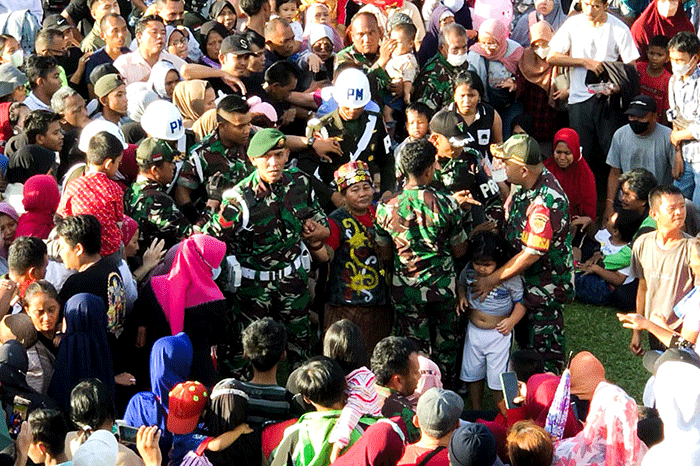Ida Dayak (tengah) dijaga provos dalam kerumunan warga yang meminta pengobatannya di Lapangan Kostrad Cilodong, Depok, Jawa Barat, Senin (3/4/2023).