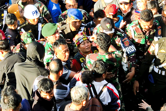 Ida Dayak (tengah) dijaga provos dalam kerumunan warga yang meminta pengobatannya di Lapangan Kostrad Cilodong, Depok, Jawa Barat, Senin (3/4/2023).