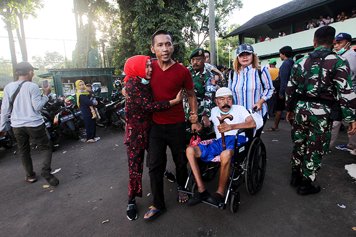 Ida Dayak (tengah) dijaga provos dalam kerumunan warga yang meminta pengobatannya di Lapangan Kostrad Cilodong, Depok, Jawa Barat, Senin (3/4/2023).