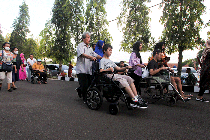 Ida Dayak (tengah) dijaga provos dalam kerumunan warga yang meminta pengobatannya di Lapangan Kostrad Cilodong, Depok, Jawa Barat, Senin (3/4/2023).