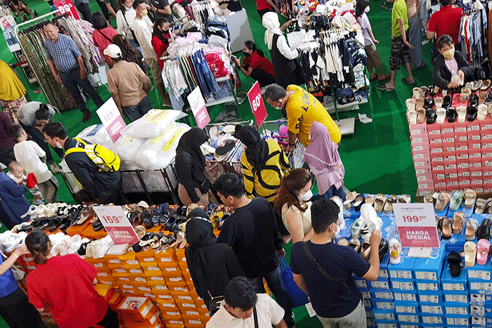Pengunjung saat memilih pakaian yang dijual diskon di Pusat Perbelanjaan, Jakarta, Minggu (2/4/2023).