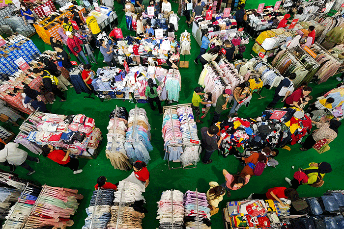 Pengunjung saat memilih pakaian yang dijual diskon di Pusat Perbelanjaan, Jakarta, Minggu (2/4/2023).