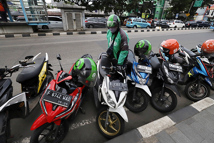 Mitra pengemudi Gojek sedang menunggu penumpang di kawasan Taman Mini Indonesia Indah (TMII), Jakarta Timur, Jumat (7/4/2023).
