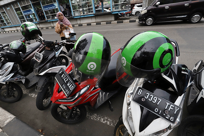 Mitra pengemudi Gojek sedang menunggu penumpang di kawasan Taman Mini Indonesia Indah (TMII), Jakarta Timur, Jumat (7/4/2023).