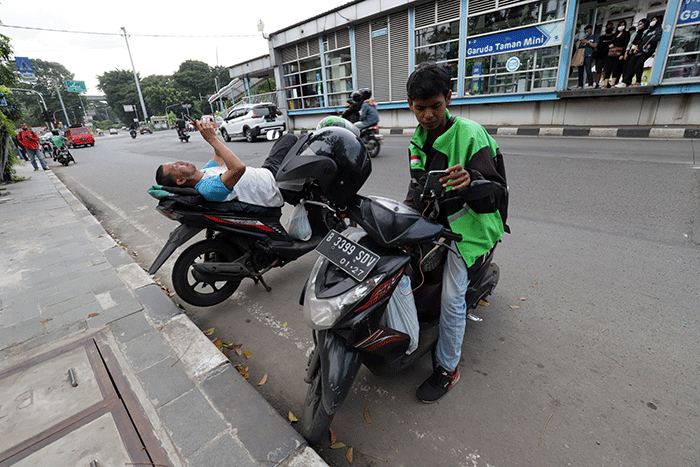 Mitra pengemudi Gojek sedang menunggu penumpang di kawasan Taman Mini Indonesia Indah (TMII), Jakarta Timur, Jumat (7/4/2023).