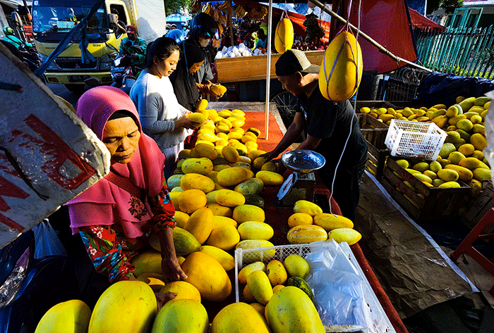 Pedagang buah saat melayani para pembeli di Pasar Tradisional, Jakarta Barat, Minggu (9/4/2023).