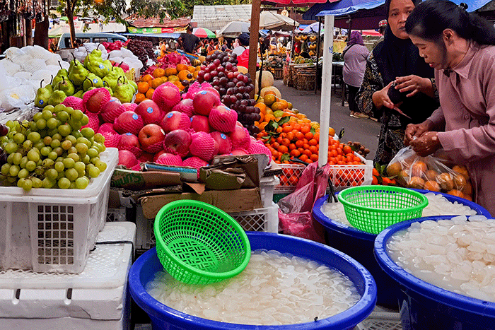 Pedagang buah saat melayani para pembeli di Pasar Tradisional, Jakarta Barat, Minggu (9/4/2023).