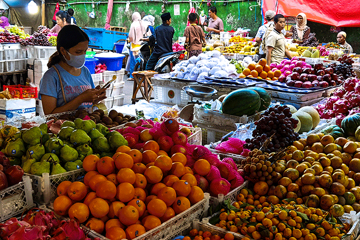 Pedagang buah saat melayani para pembeli di Pasar Tradisional, Jakarta Barat, Minggu (9/4/2023).