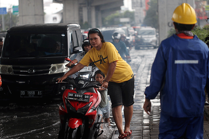 Sejumlah kendaraan bermotor menerobos banjir di Jalan AP Pettarani, Makassar, Senin (10/4/2023).