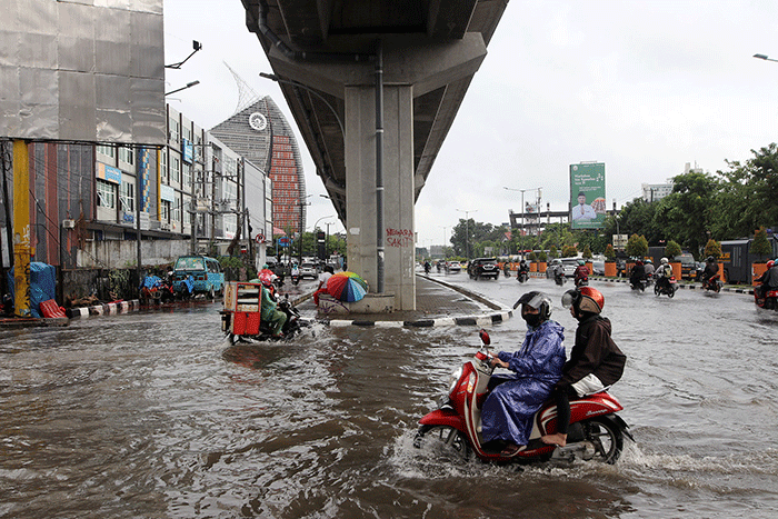 Sejumlah kendaraan bermotor menerobos banjir di Jalan AP Pettarani, Makassar, Senin (10/4/2023).
