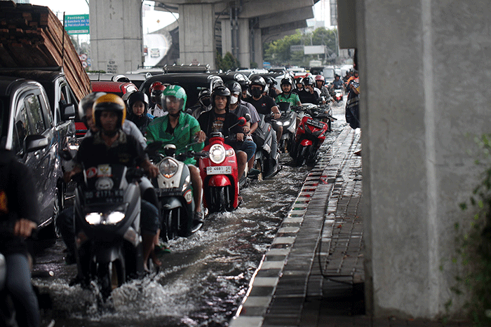 Sejumlah kendaraan bermotor menerobos banjir di Jalan AP Pettarani, Makassar, Senin (10/4/2023).