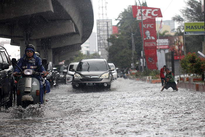Sejumlah kendaraan bermotor menerobos banjir di Jalan AP Pettarani, Makassar, Senin (10/4/2023).