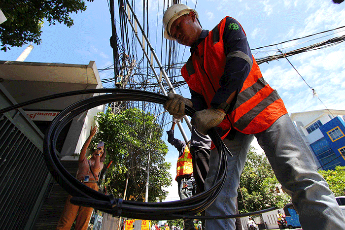 Petugas melakukan perapihan jaringan fiber optic Iconnet milik PLN Icon Plus di Jalan Tugu Proklamasi, Jakarta, Rabu (12/4/2023).