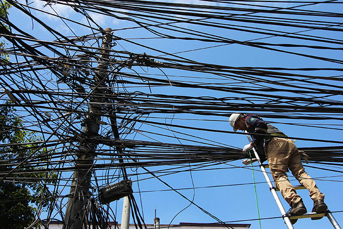 Petugas melakukan perapihan jaringan fiber optic Iconnet milik PLN Icon Plus di Jalan Tugu Proklamasi, Jakarta, Rabu (12/4/2023).